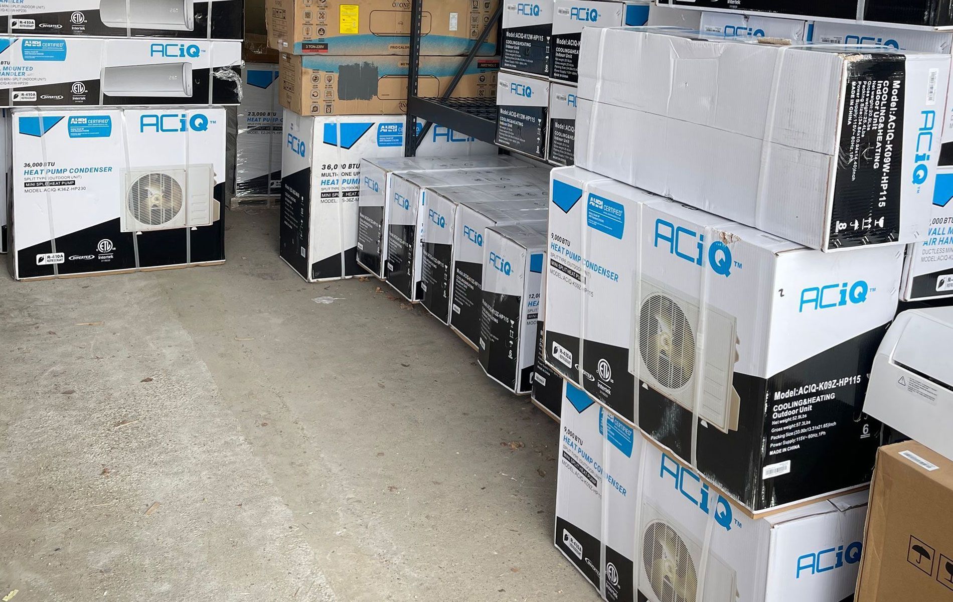 Boxes of AC units stacked in a warehouse. White boxes with blue and black graphics.