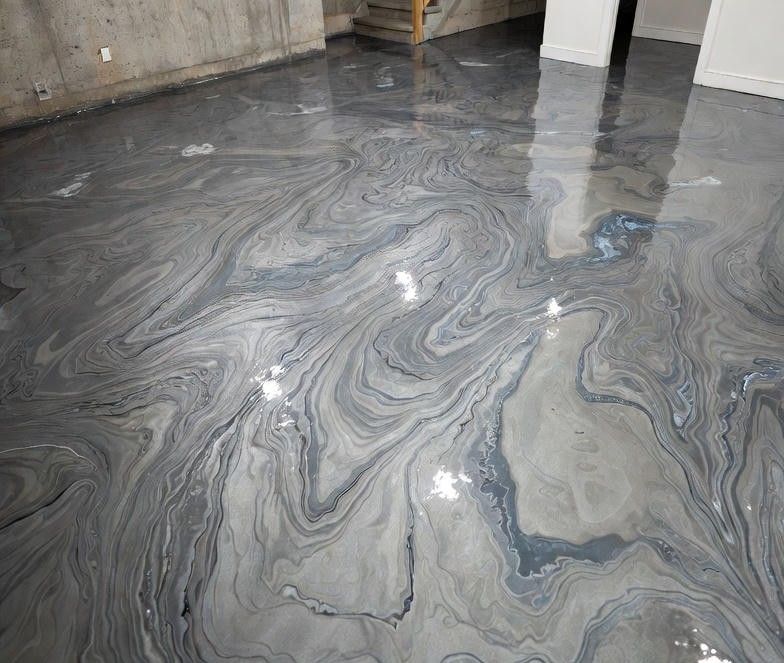 Swirled epoxy floor with shades of gray and blue, creating an abstract marble-like design.