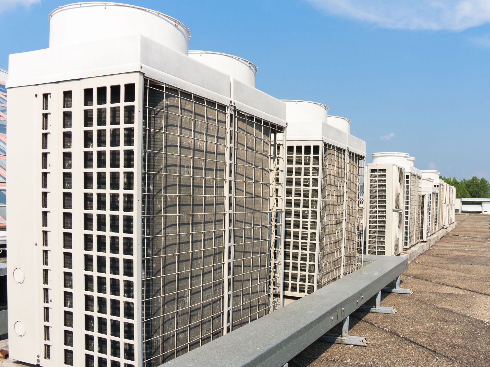 Row of commercial HVAC units on a rooftop.