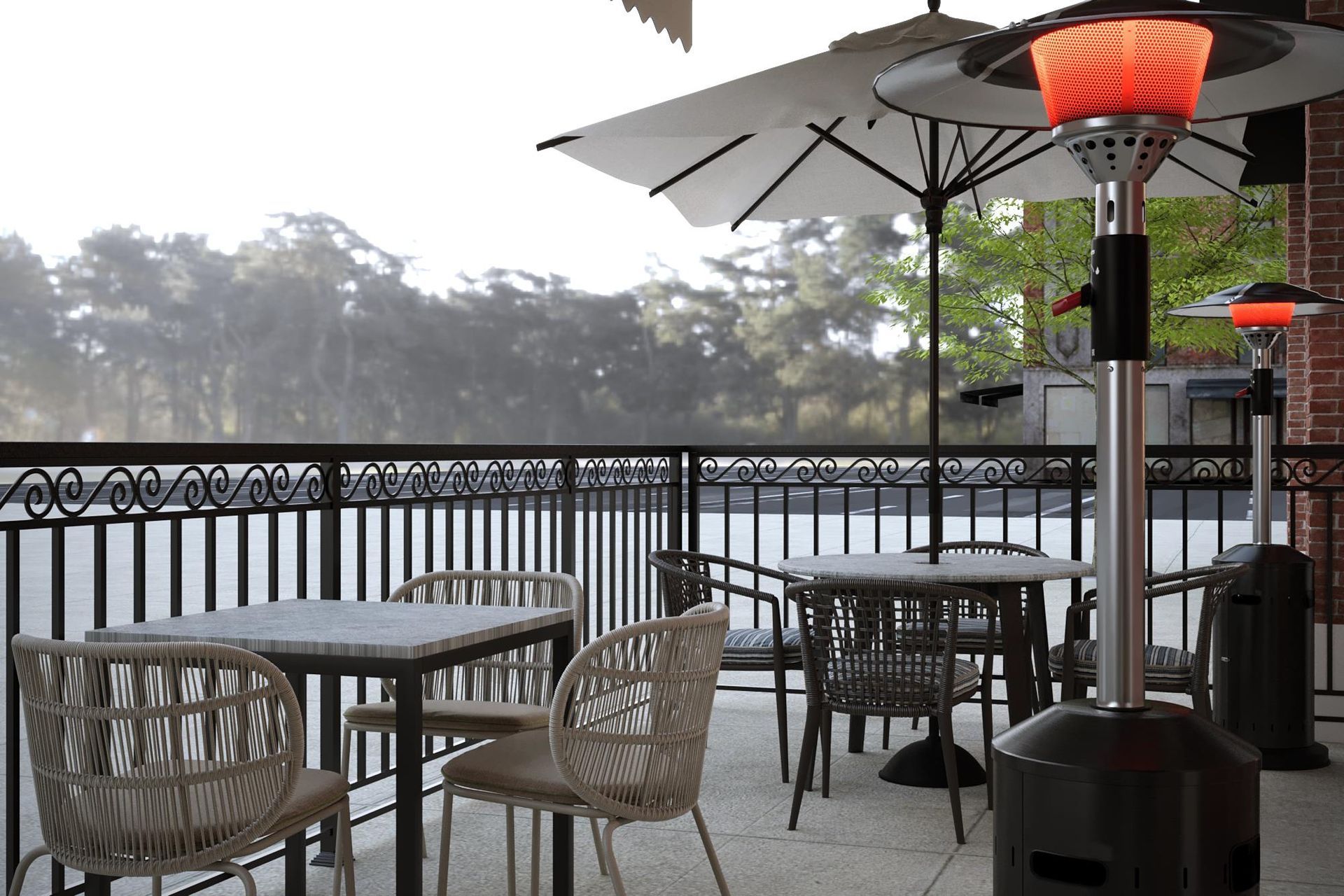 Outdoor patio with tables, chairs, and heaters, overlooking water. Cloudy day.