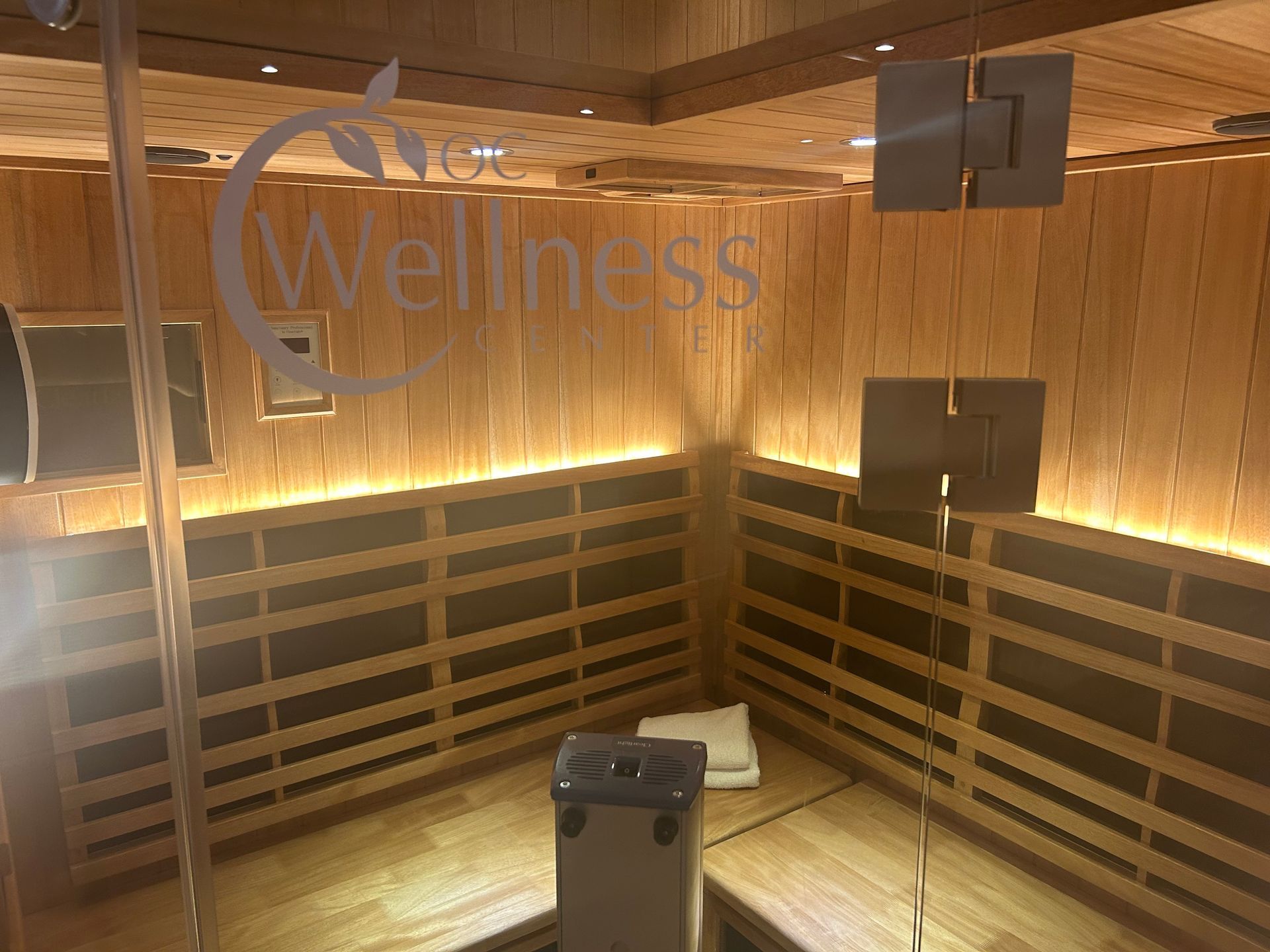 A wooden sauna with a sign that says wellness on the wall.