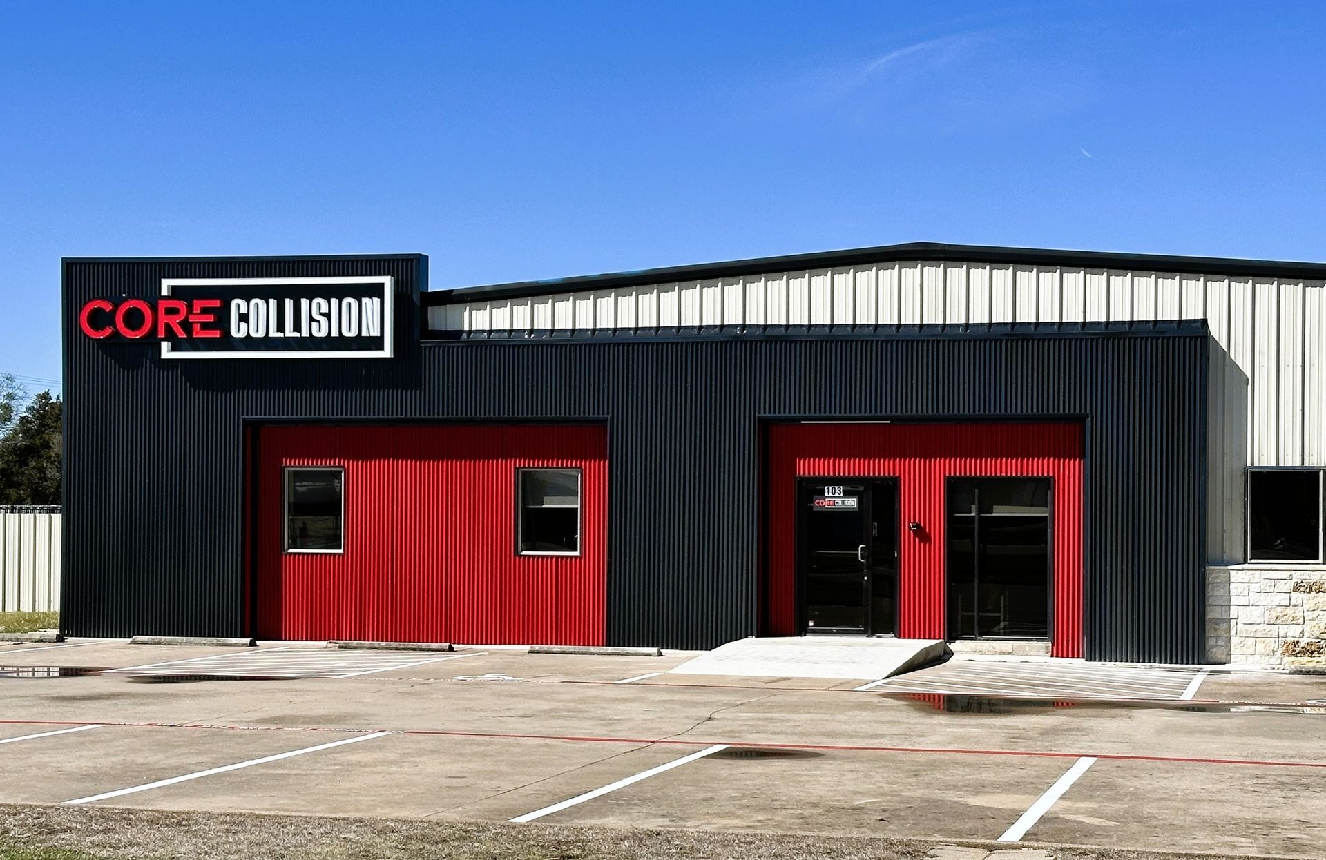 Core Collision auto body shop exterior with red accents and black siding.