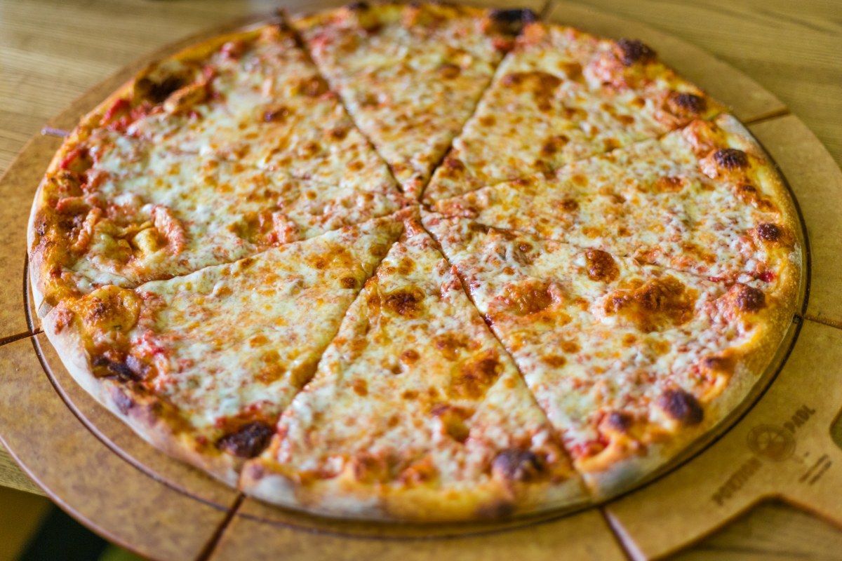 Cheese pizza sliced into eight wedges on a wooden serving board.