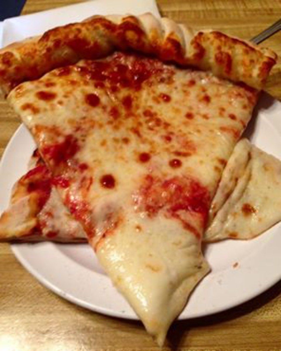 Pizza slices on a white plate; cheese, sauce visible.