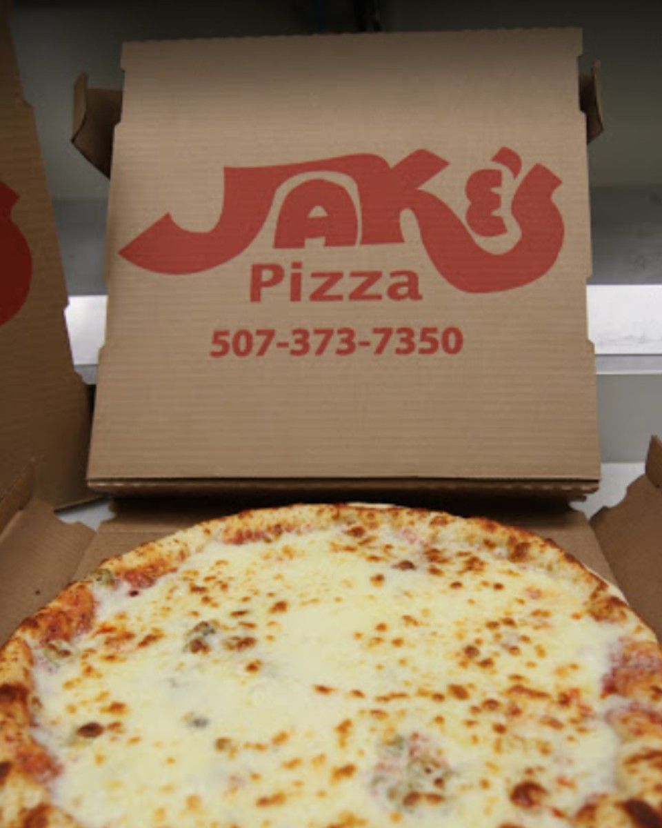 Pizza in a box from Jak's Pizza, 507-373-7350, with a cheesy, golden crust.