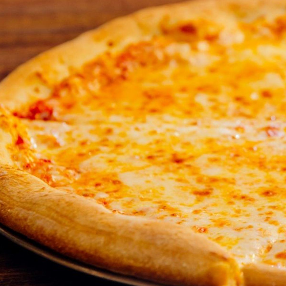 Cheese pizza close-up with melted mozzarella and golden crust.