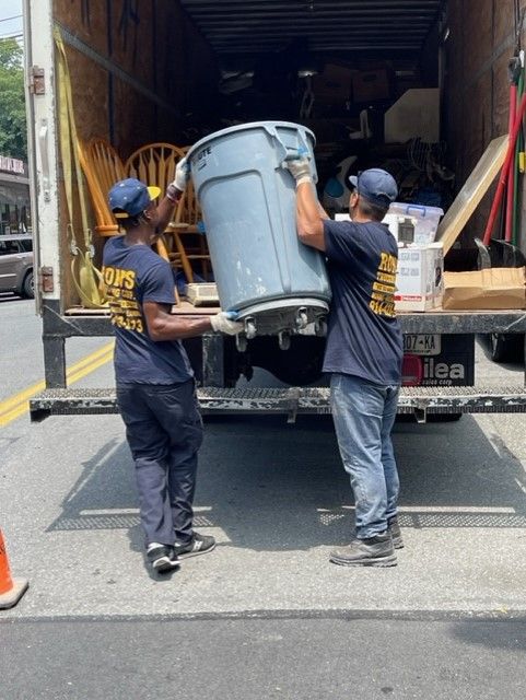 two men carrying a big pail to the truck