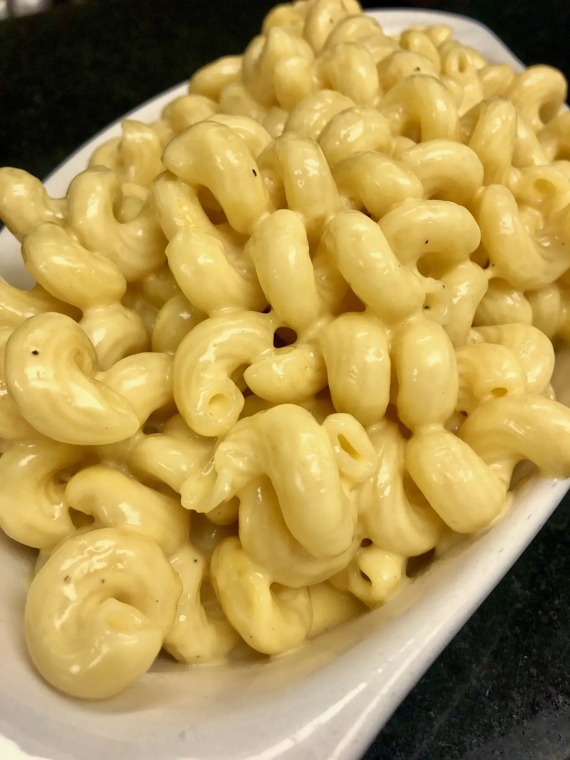 Creamy macaroni and cheese on a white spoon-shaped dish