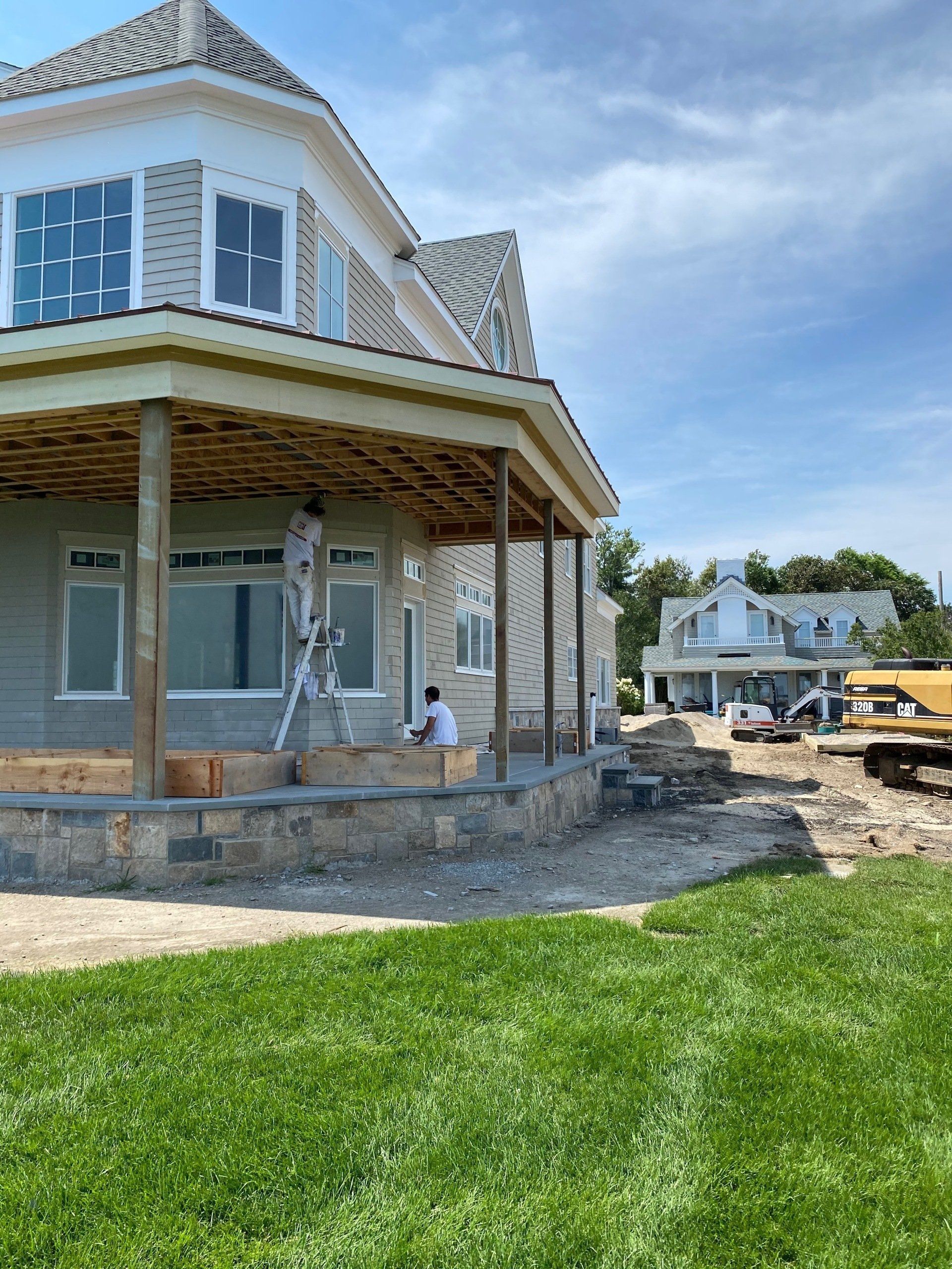 A man sitting on a porch next to a house under construction