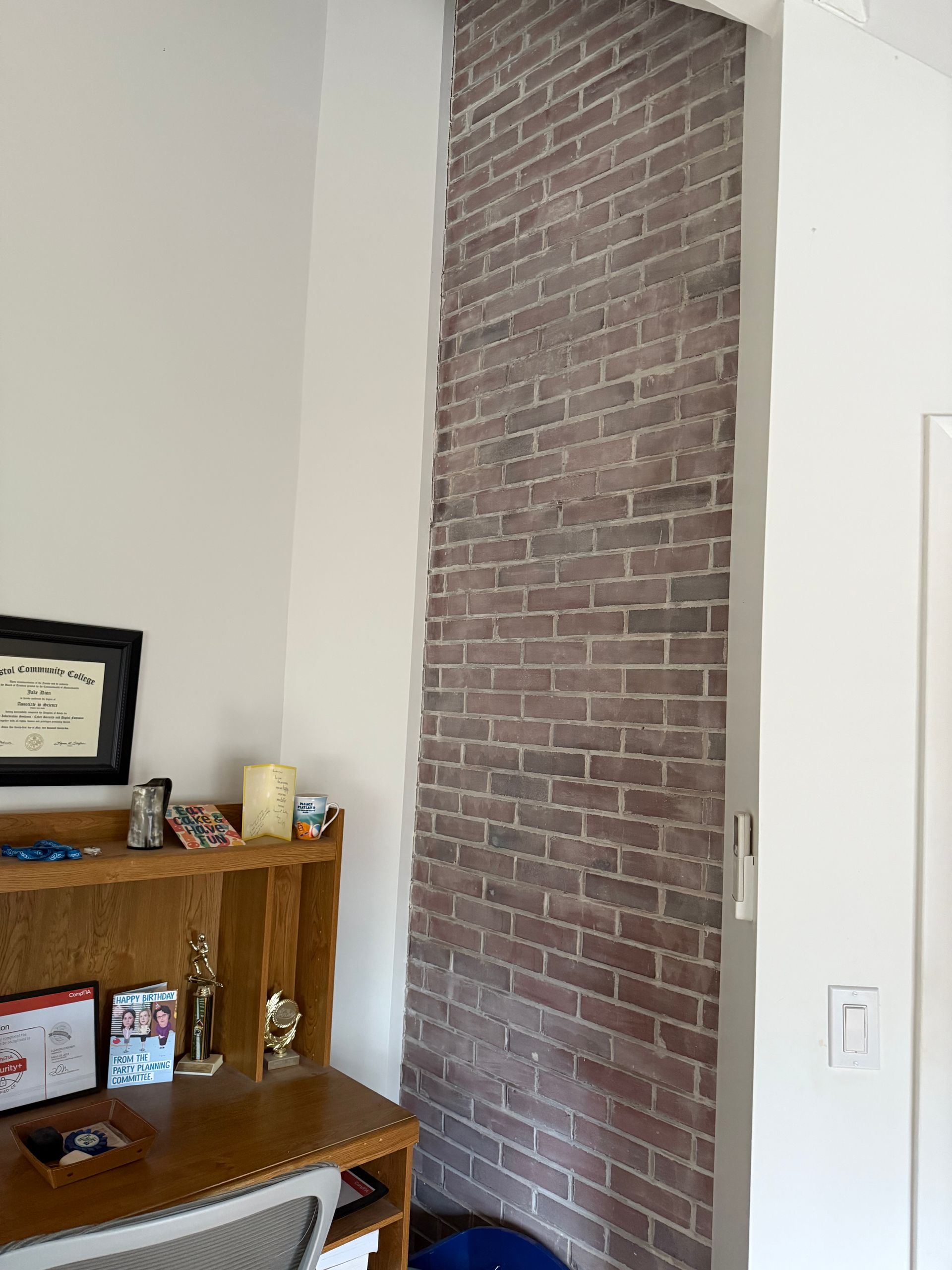 There is a brick wall in the corner of the room.