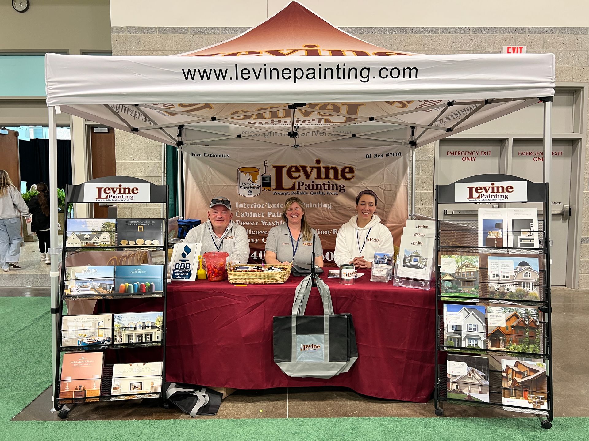 A group of people standing around a table under a tent.