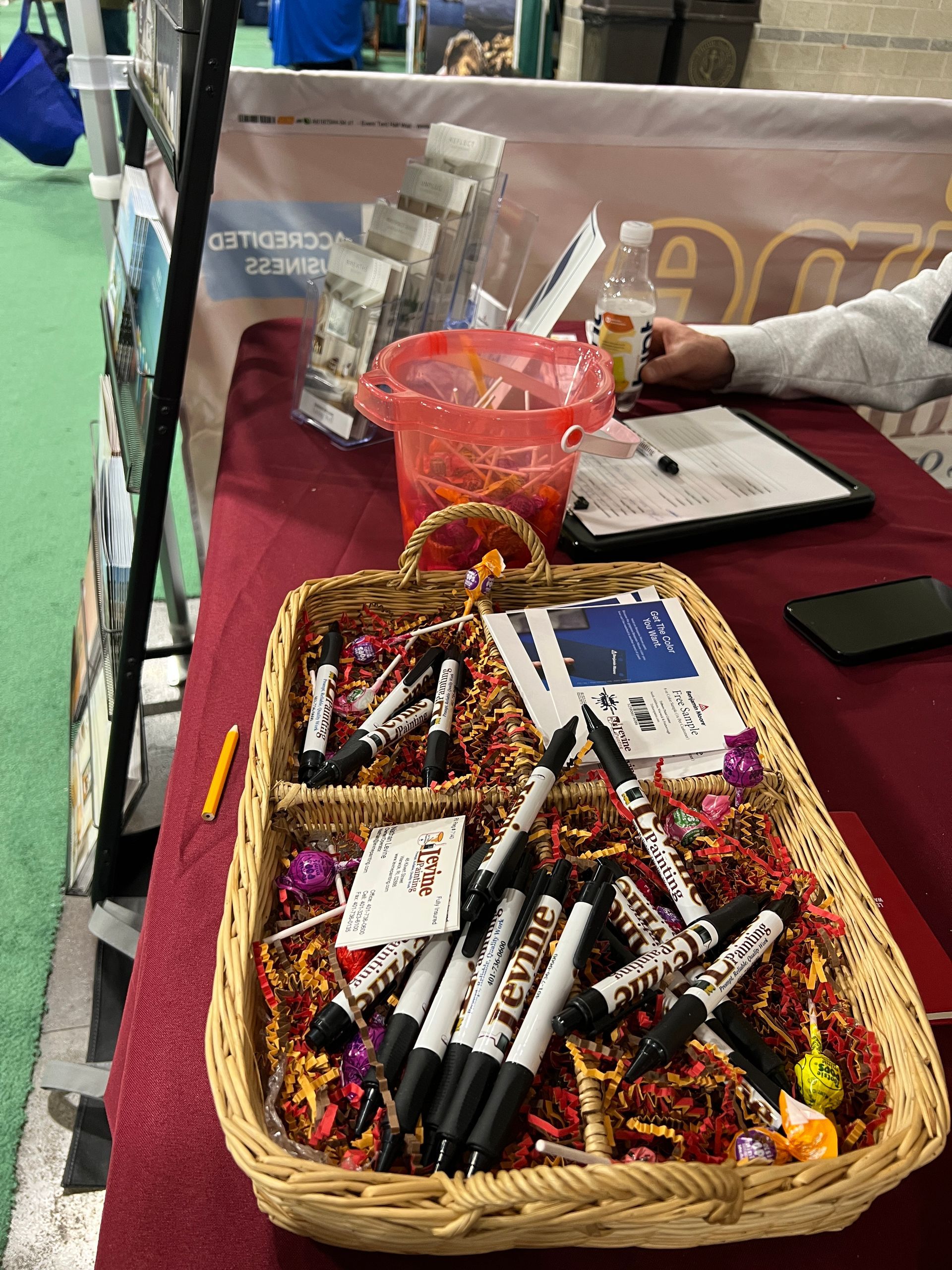 A basket filled with markers and candy is on a table.
