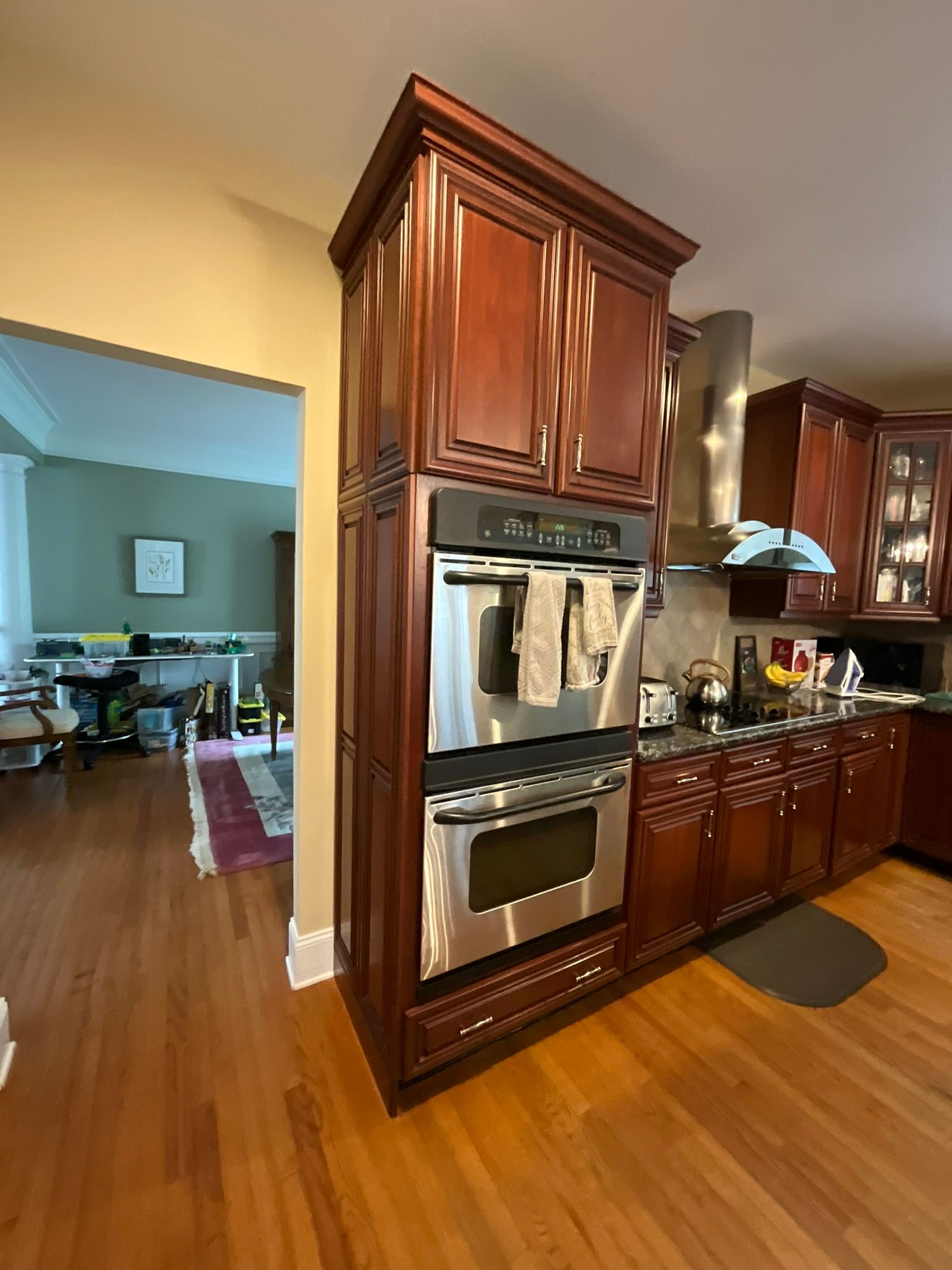 Kitchen with dark wood cabinets, stainless steel appliances, and hardwood floors.