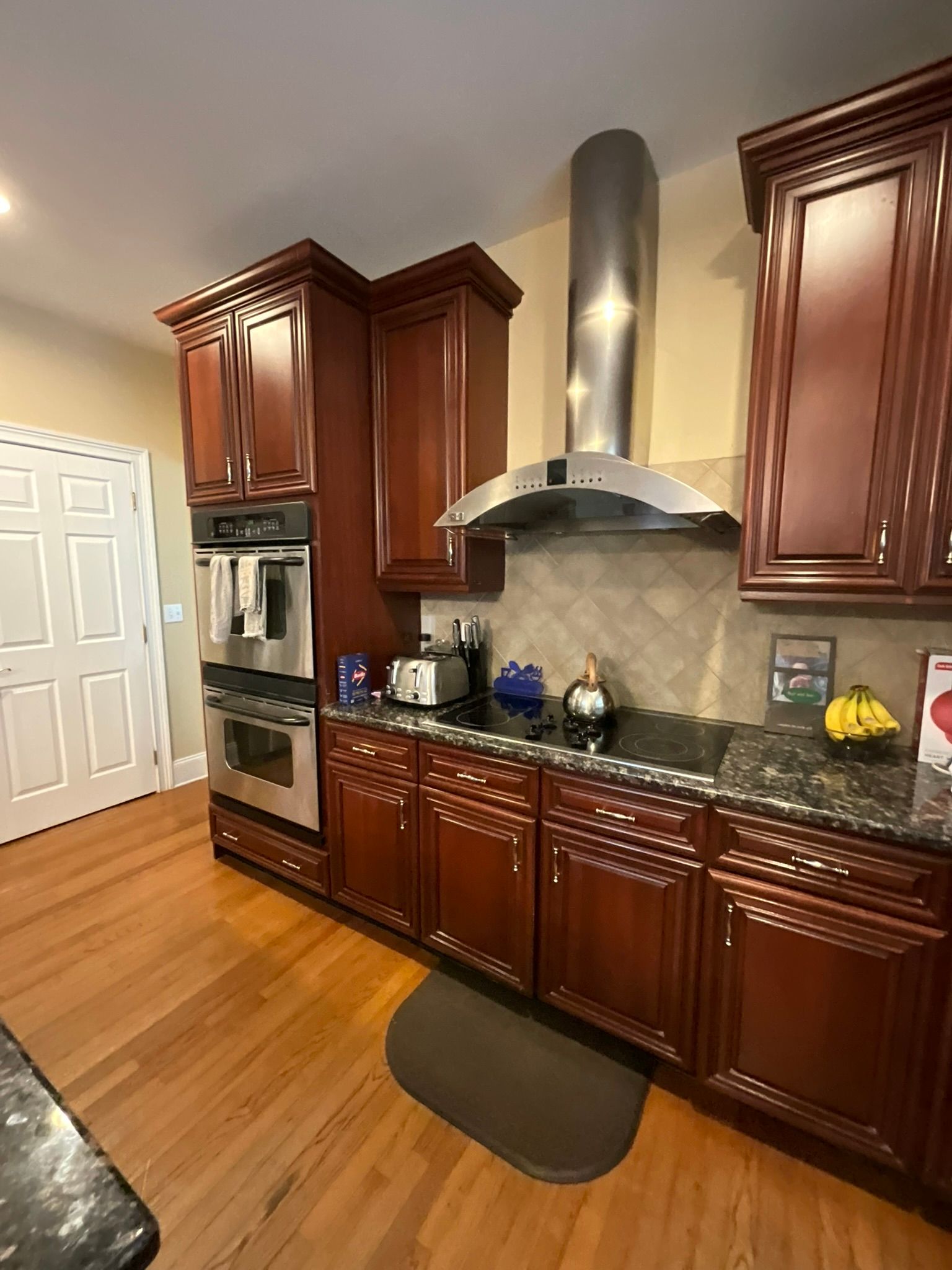 Kitchen with cherry cabinets, stainless steel appliances, and hardwood floors.