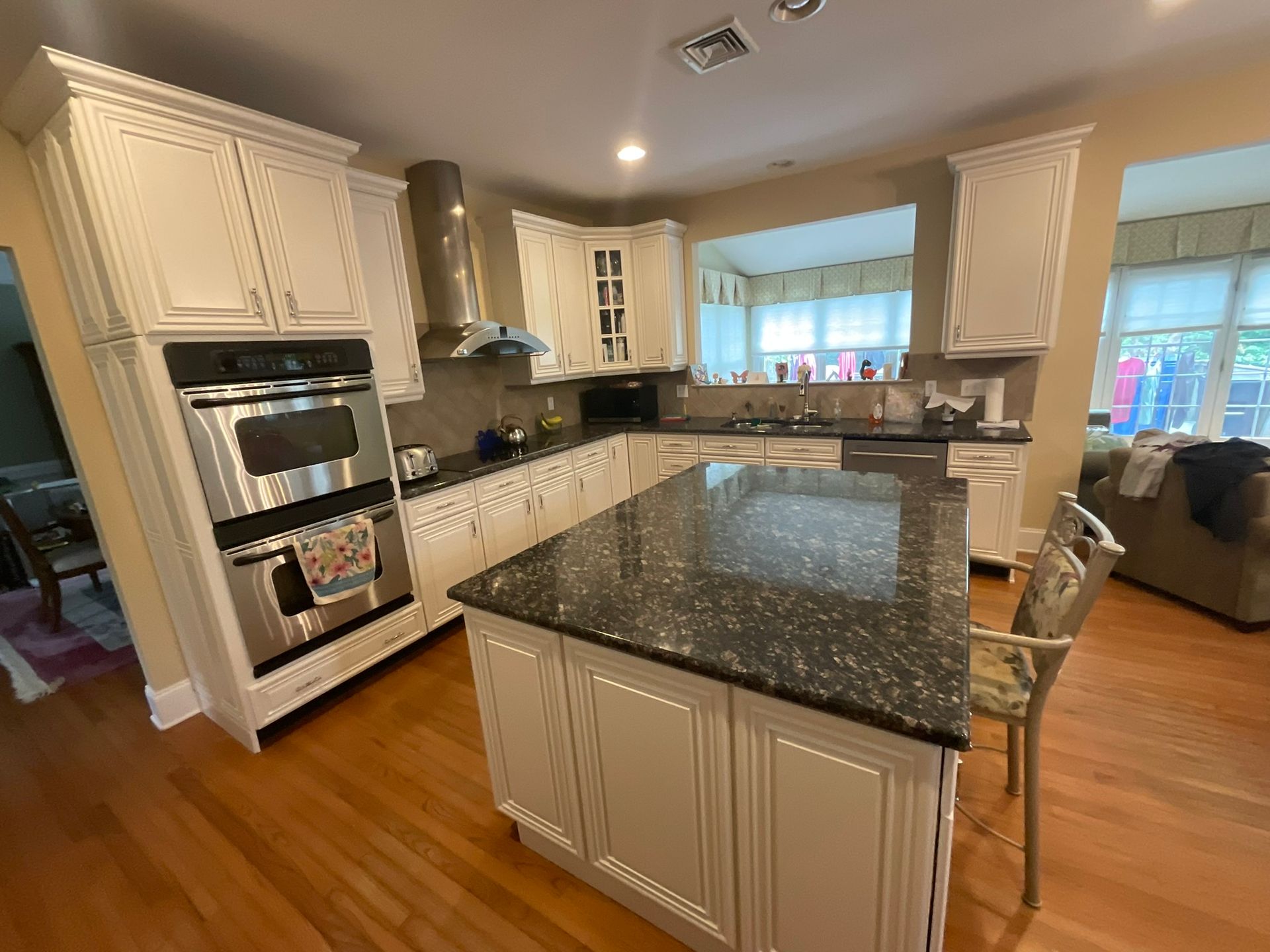 Kitchen with white cabinets, granite countertops, and stainless steel appliances.