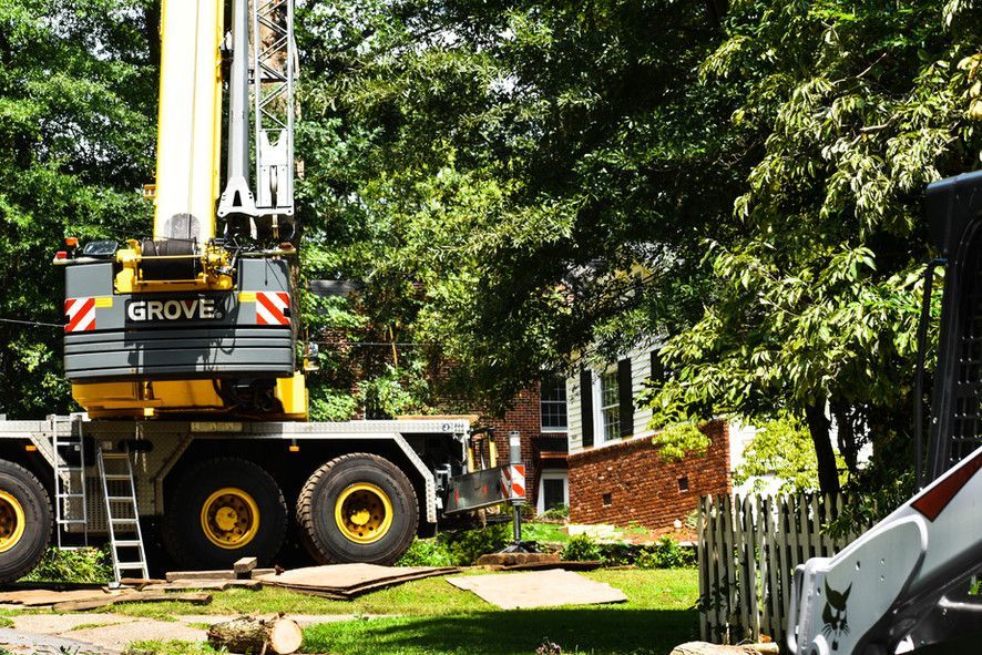 A grove crane is parked in front of a house