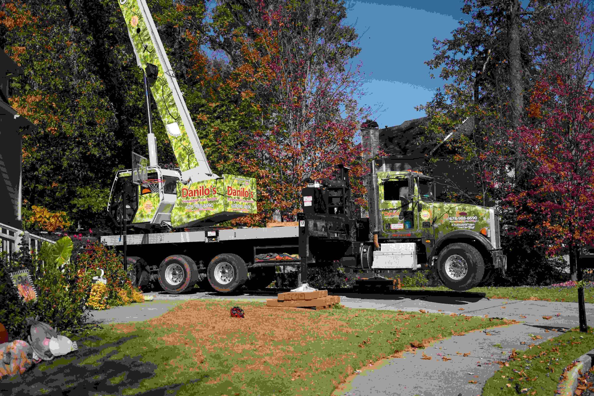 A truck with a crane on top of it is parked in front of a house.