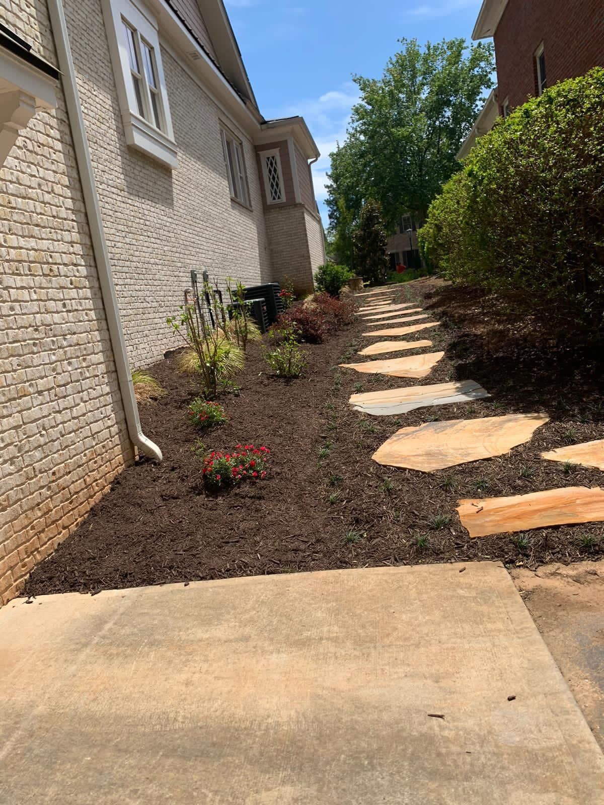 A brick house with a stone walkway leading to it.