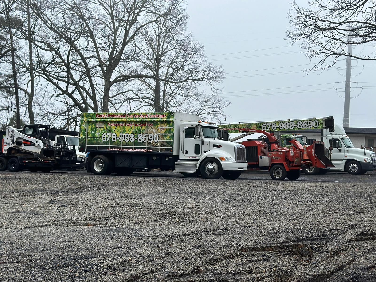 A group of trucks are parked in a gravel lot.