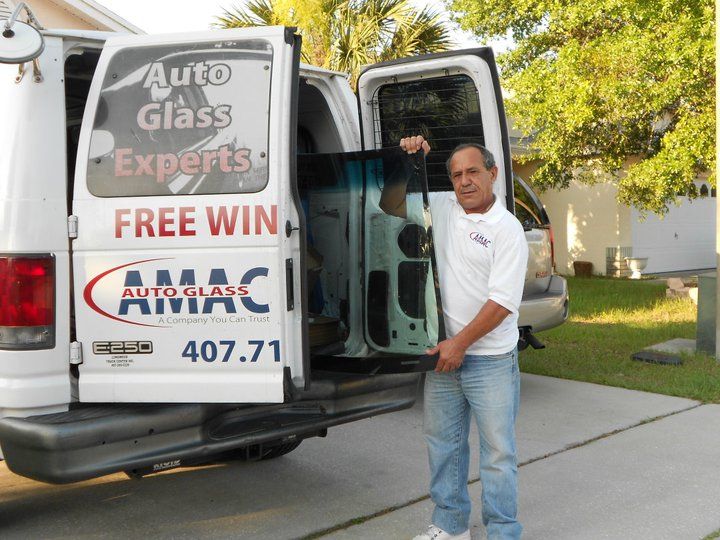 A man is standing in front of an auto glass van