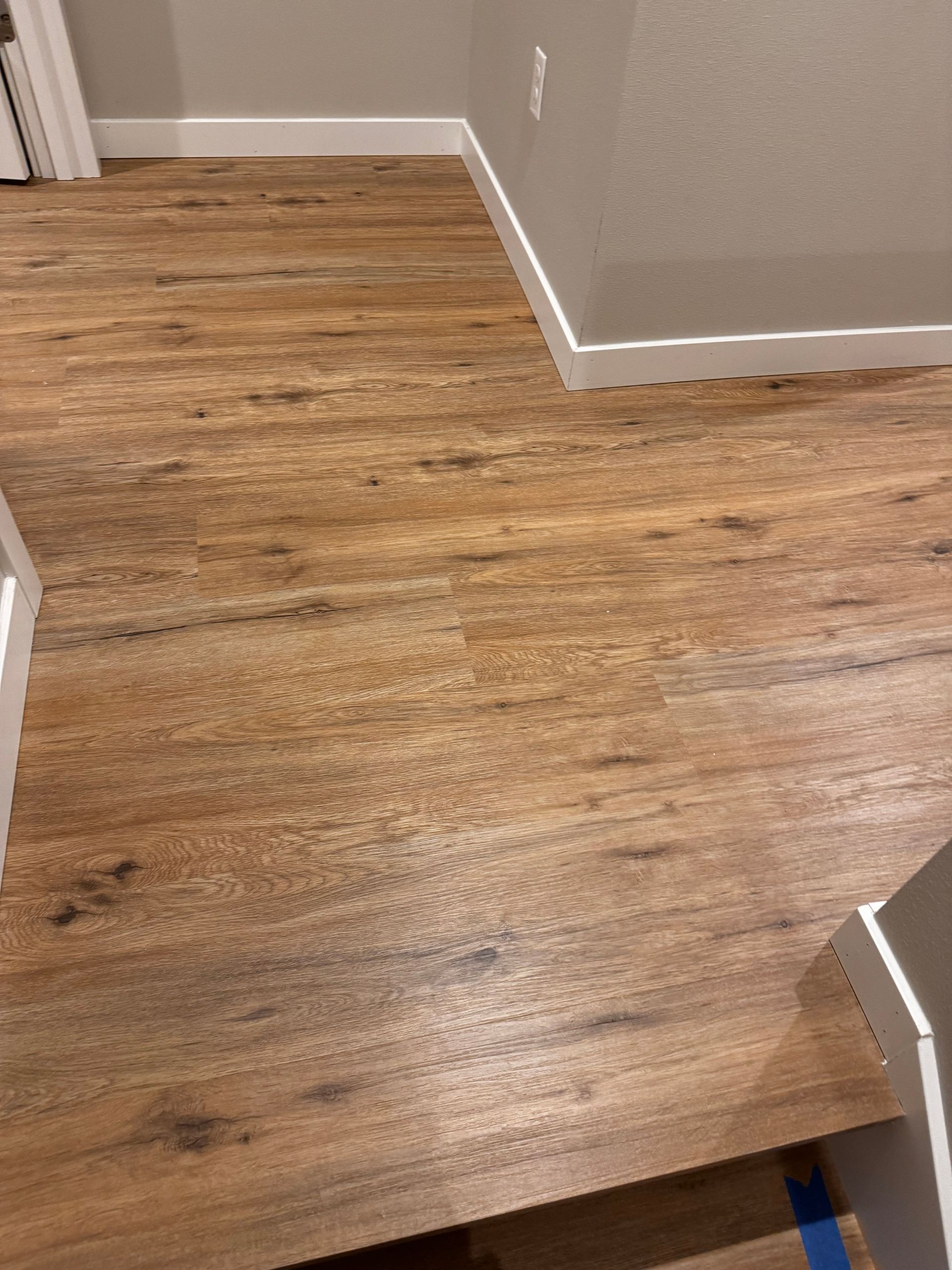 Wood-look flooring in a room with white trim and gray walls.