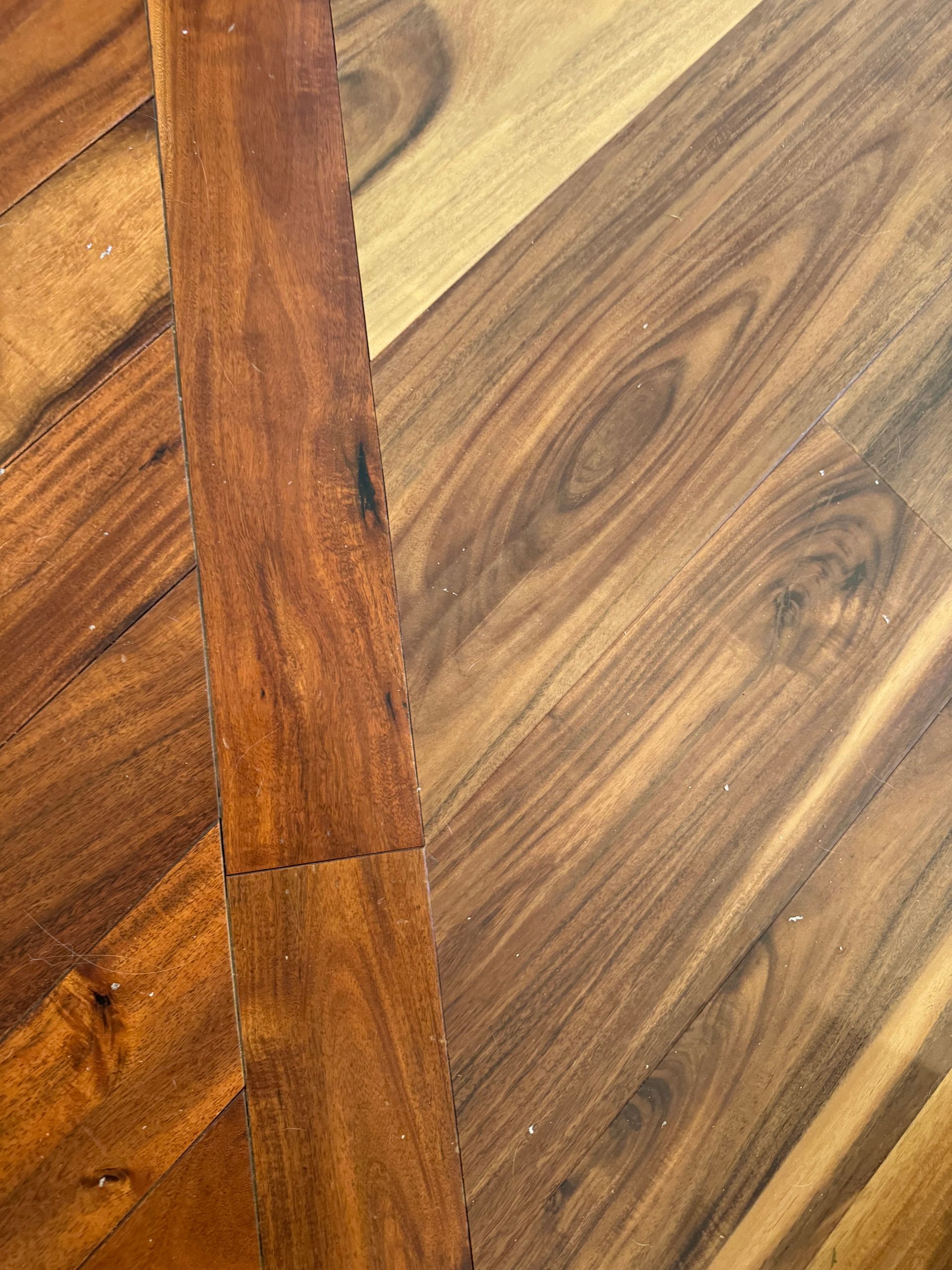 Close-up of hardwood flooring, warm brown tones, varying wood grain patterns and tones.