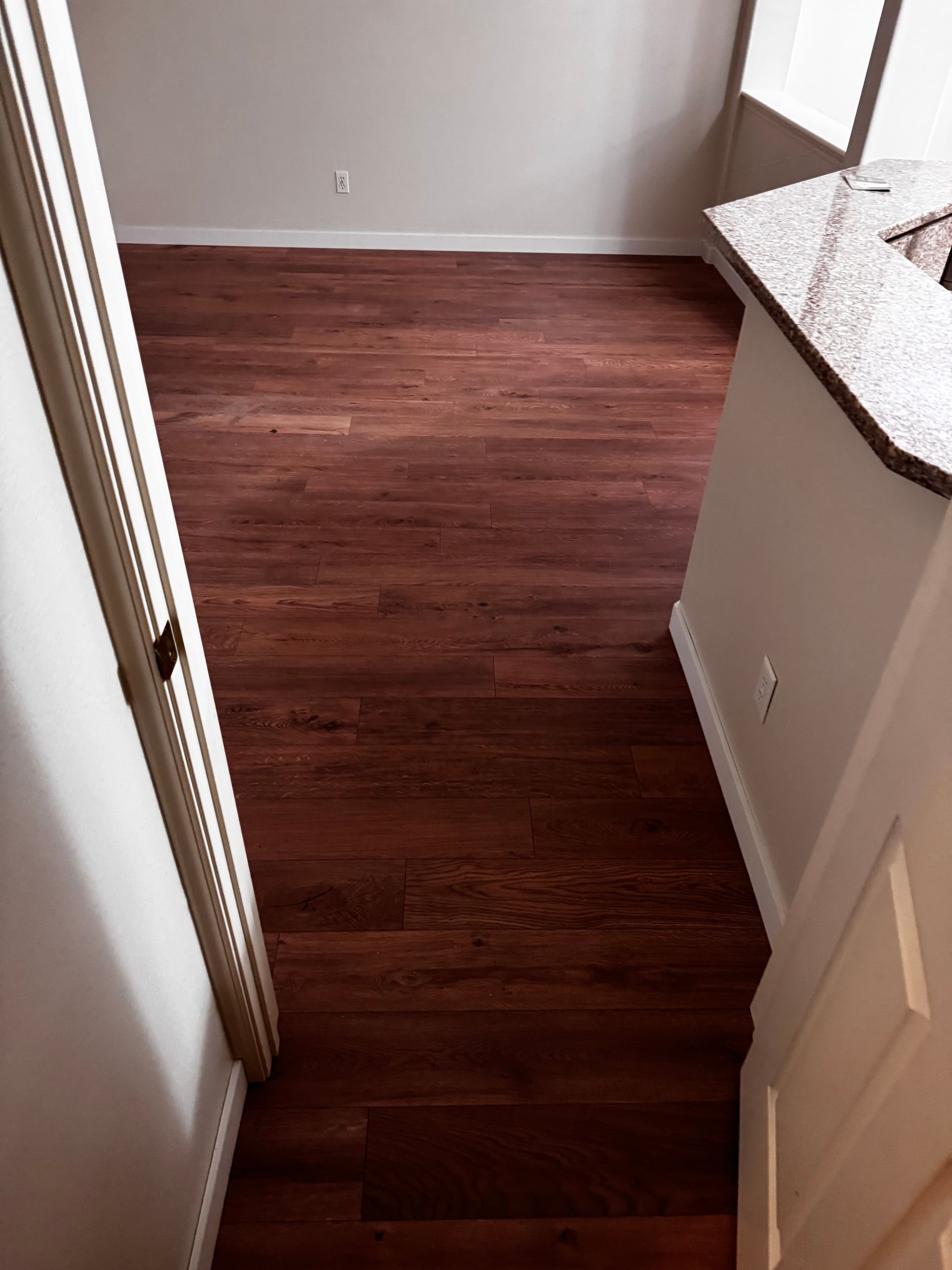 Hardwood floor interior with wall, door, and counter.