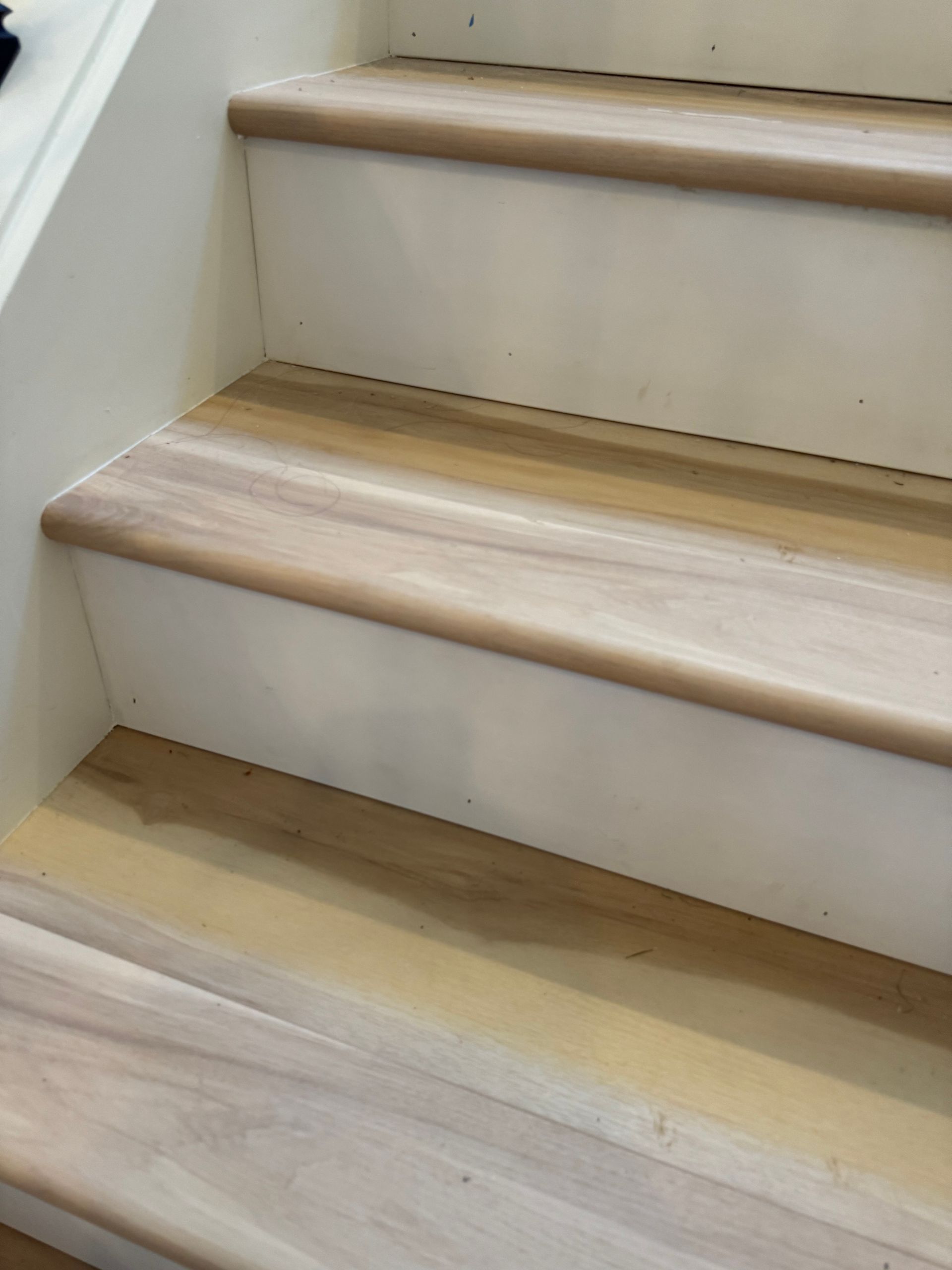 Wooden staircase with light brown treads and white risers.