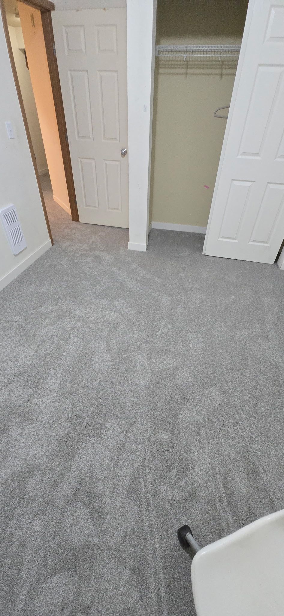 Room with new gray carpet, doors, and a closet.