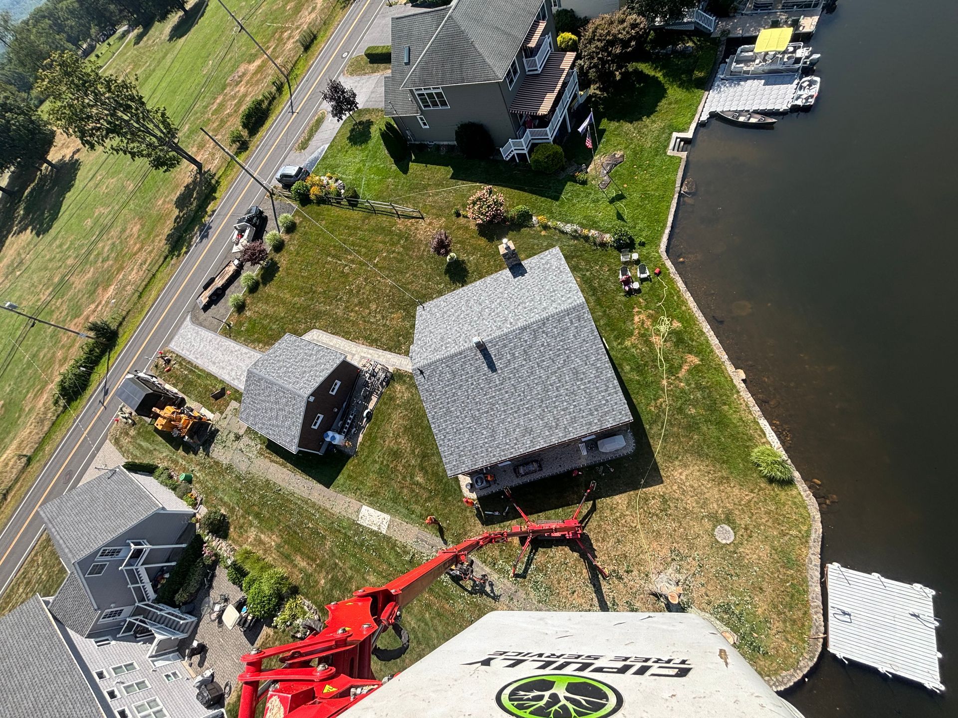 Aerial view of houses along a waterway; construction equipment visible.