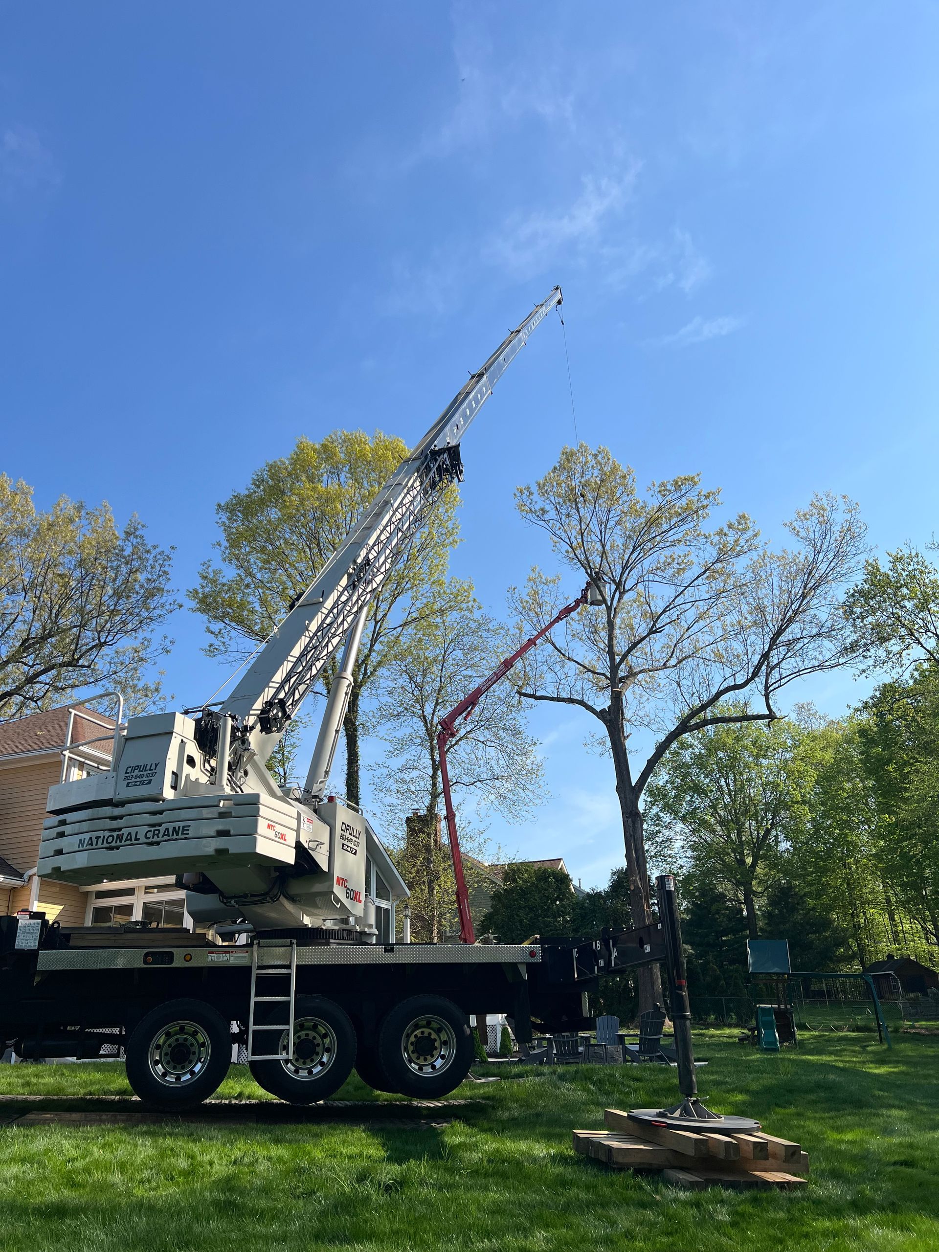 A large crane is sitting on top of a truck in a park.