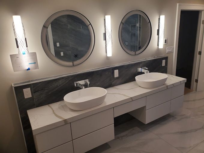 A bathroom with two sinks and three mirrors.