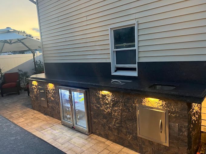 A kitchen with a refrigerator and a sink in front of a house.