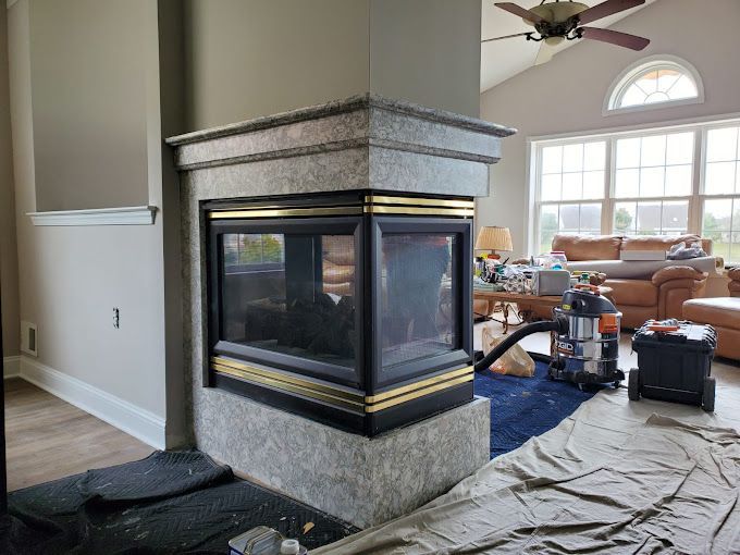 A living room with a fireplace and a ceiling fan.