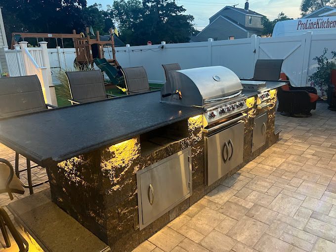 A large outdoor kitchen with a grill and a table.