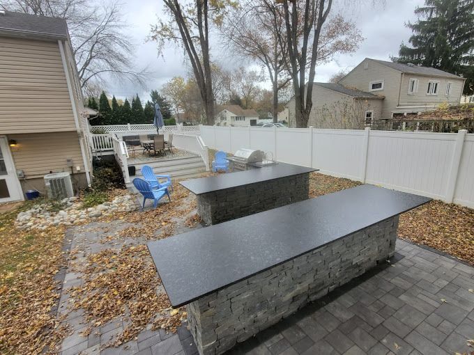 There are three tables in the backyard of a house.