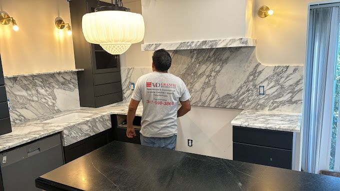 A man in a white shirt is standing in a kitchen.