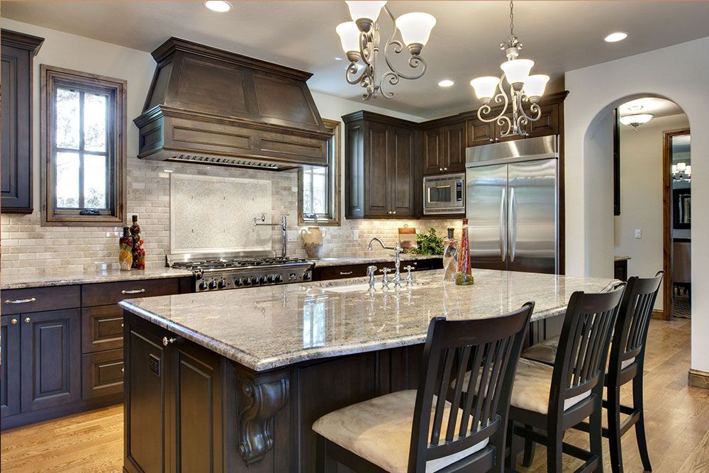 A kitchen with a large island and stainless steel appliances