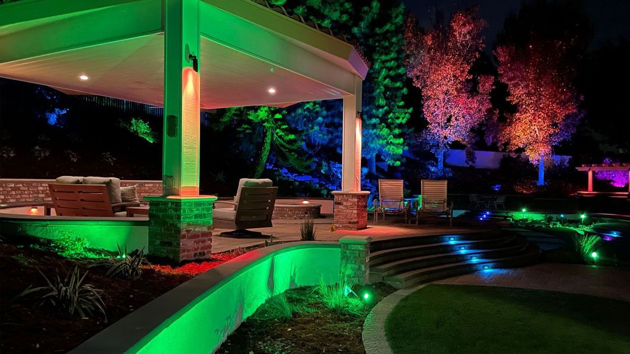 A patio area with green and blue lights at night.