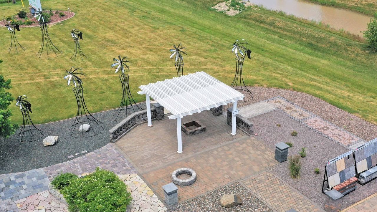 An aerial view of a backyard with a pergola and a fire pit.