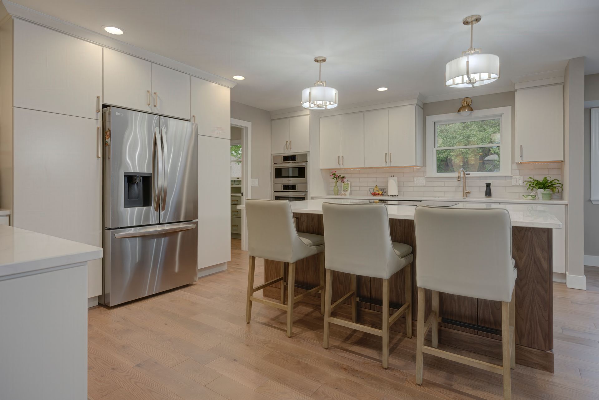 A kitchen with stainless steel appliances, white cabinets, and a large island.