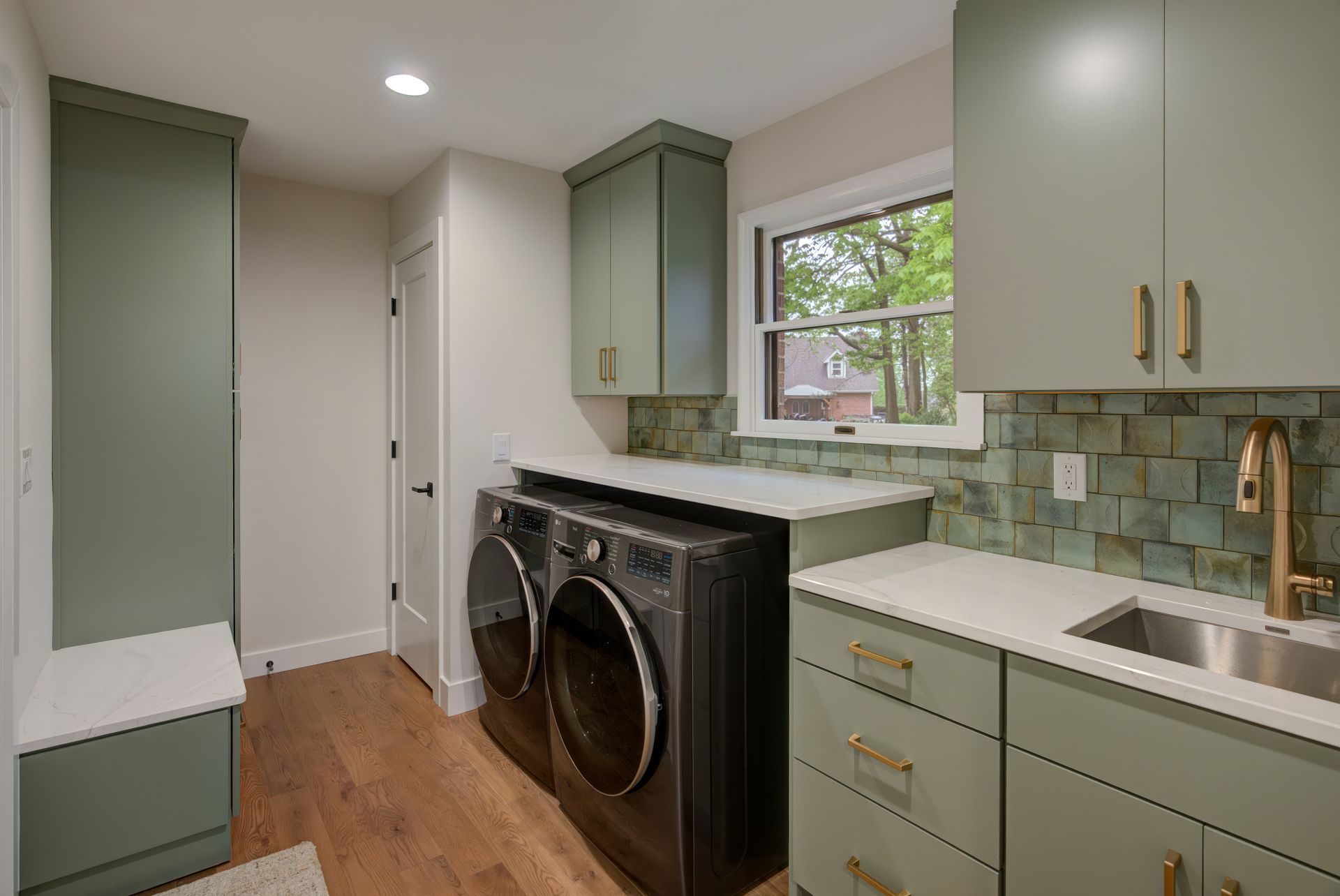 A laundry room with a washer and dryer and a sink.