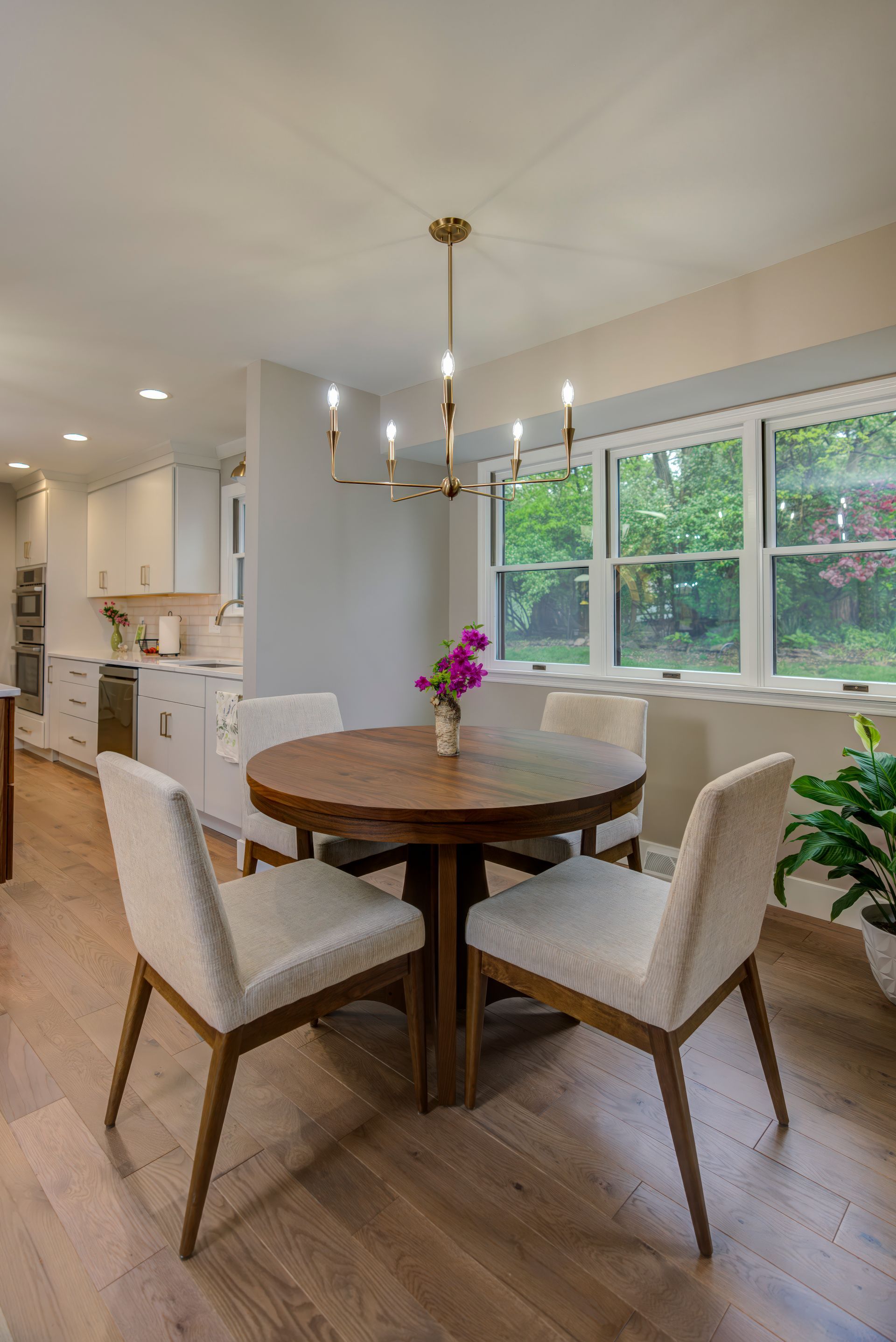 A dining room with a round table and chairs and a chandelier.
