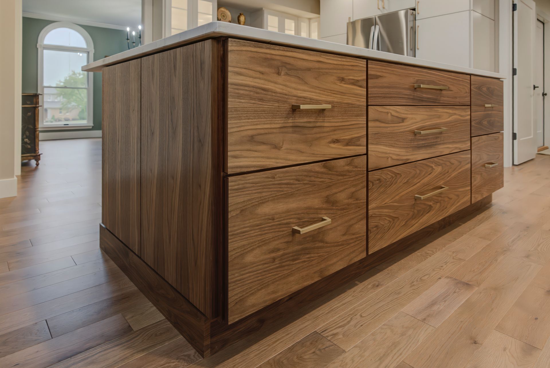 A kitchen island with wooden drawers and a marble counter top.