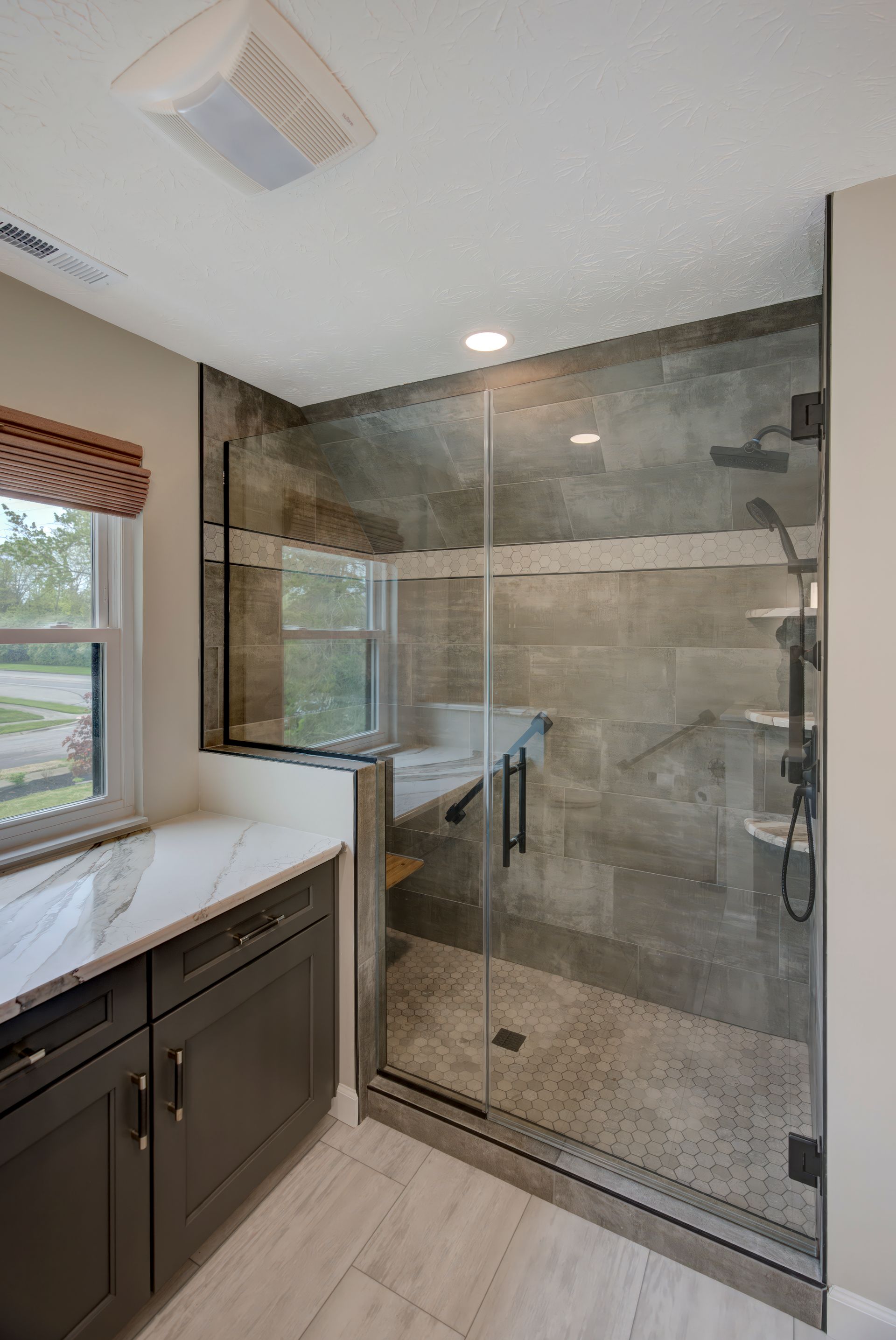 A bathroom with a walk in shower and a window.