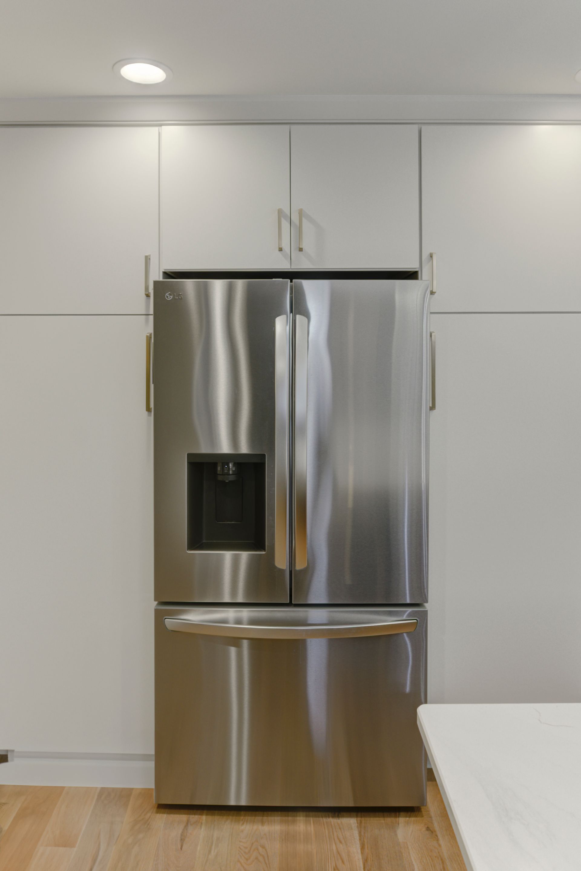 A stainless steel refrigerator is sitting in a kitchen next to a counter.