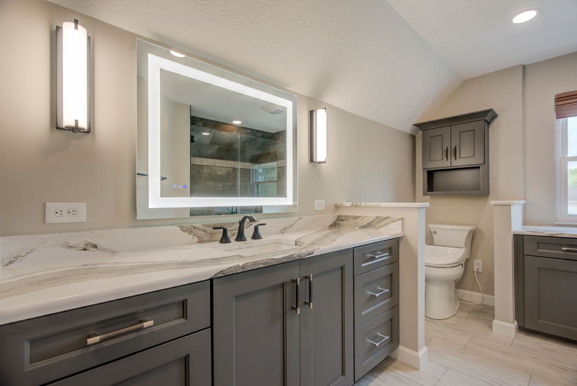 A bathroom with two sinks, a toilet, and a large mirror.