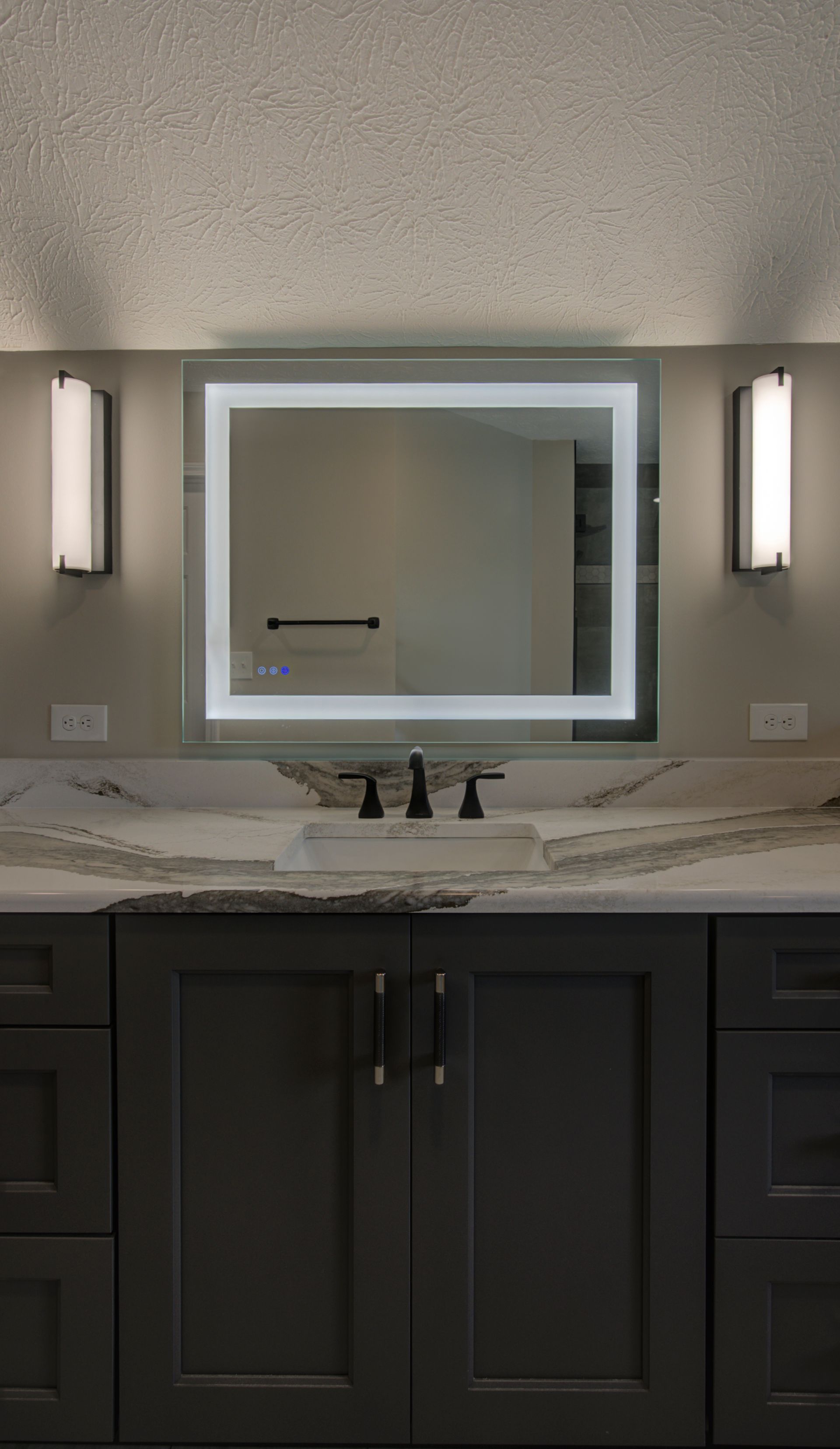 A bathroom with a sink, mirror and cabinets.