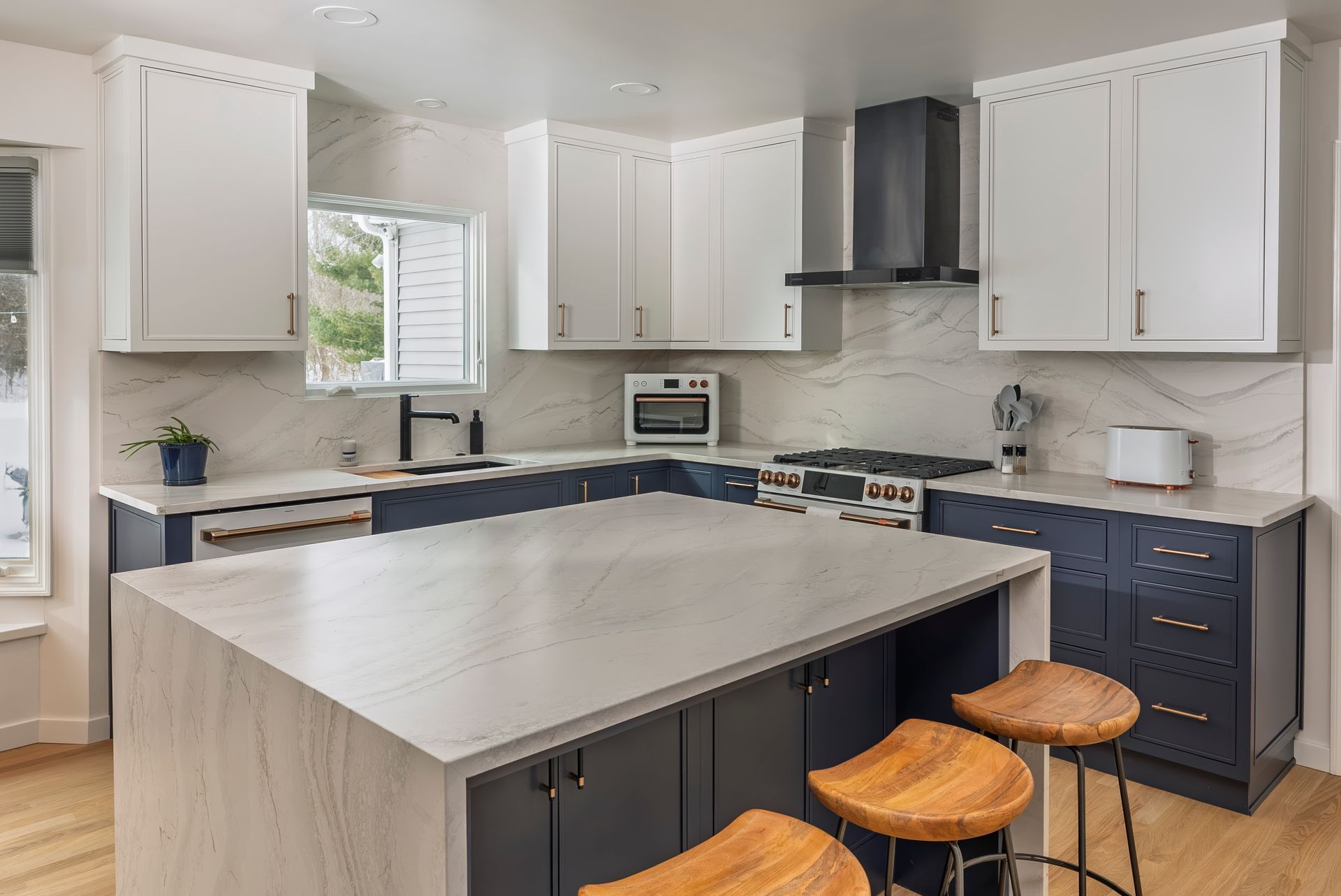 A kitchen with white cabinets, blue cabinets, and a large island.
