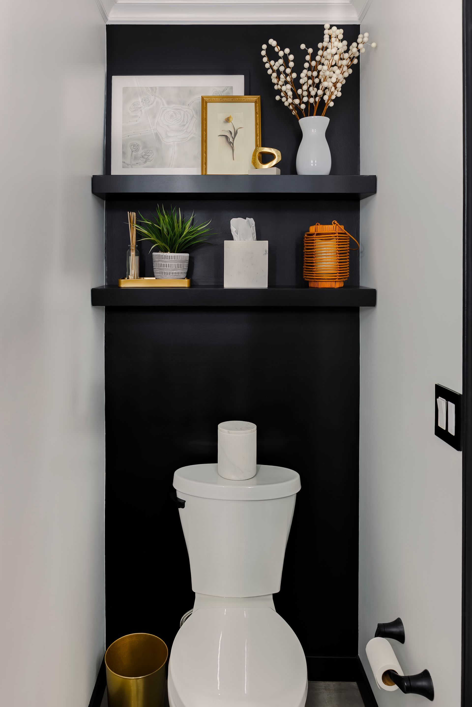 A toilet with a roll of toilet paper on top of it in a bathroom.